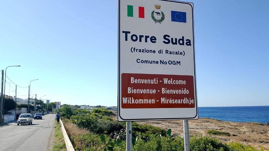 een bord aan de kant van een weg naast de oceaan bij Vento sulle Onde - Casa Nunù in Torre Suda