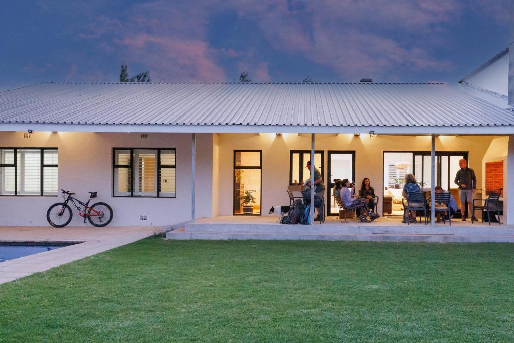 a group of people sitting outside of a house at De Hoop Farm - Mountain View in Breërivier