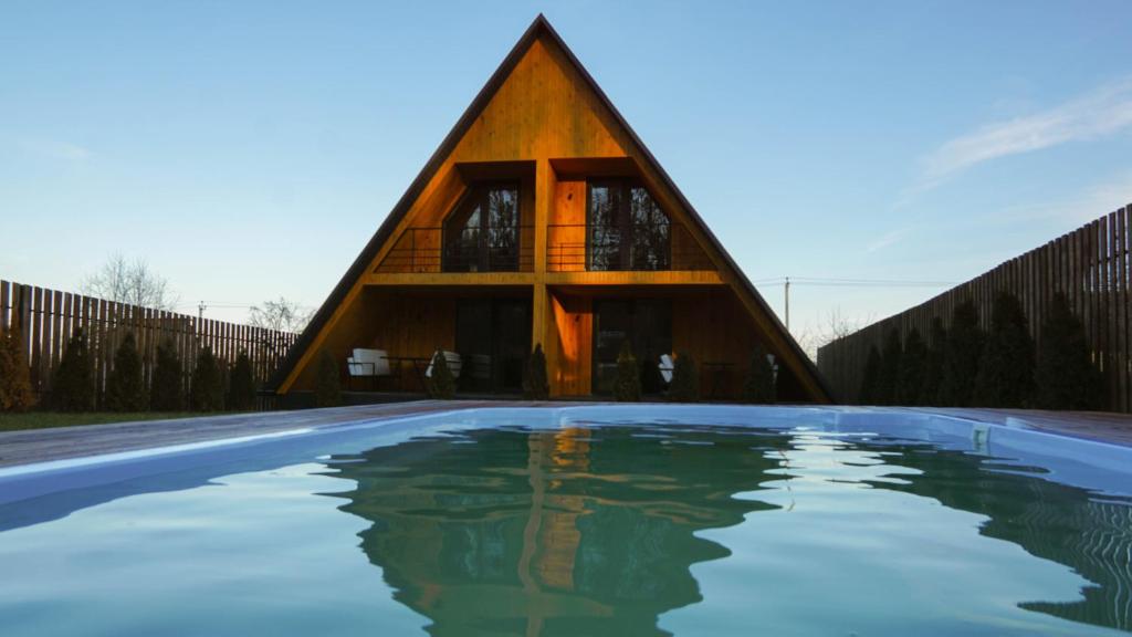 a house shaped like a pyramid with a swimming pool at Rancho in Ladyzhyn