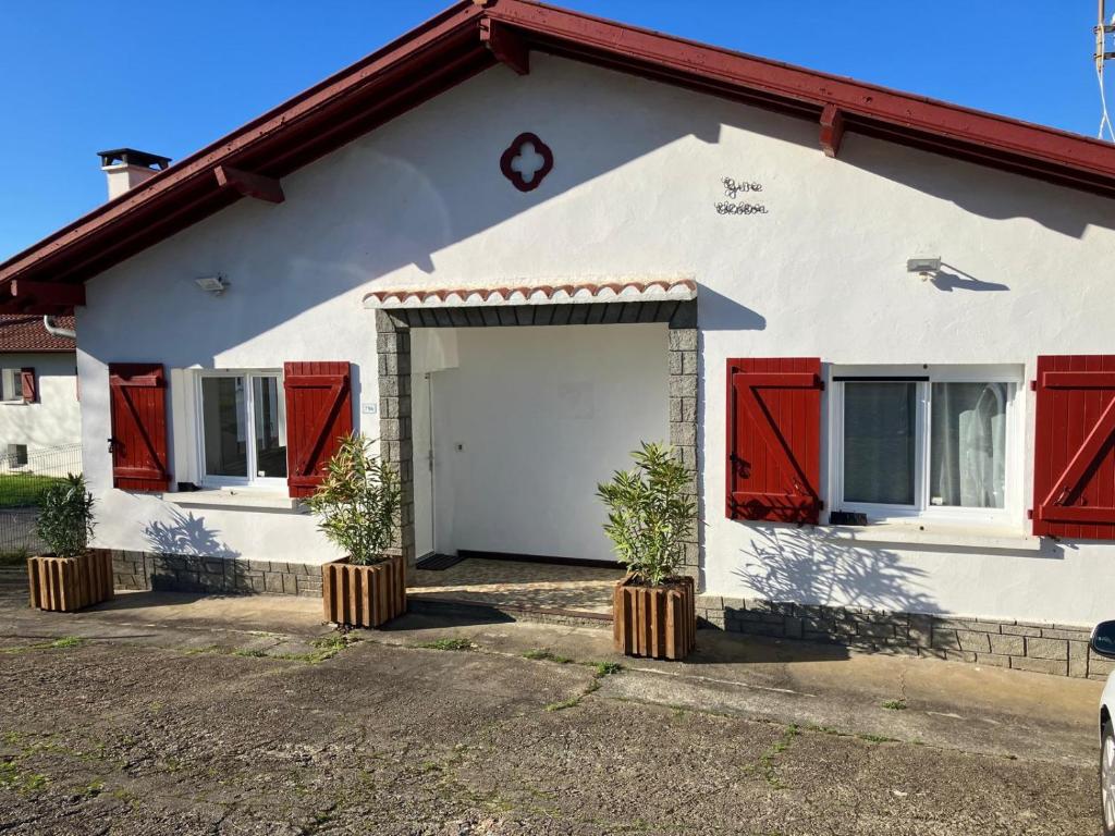 a white and red house with red shutters at Maison Gure Chokoa Pays Basque in Bardos