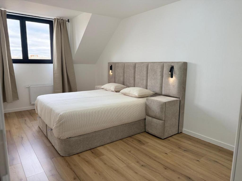 una camera da letto con un letto grande con lenzuola bianche di Skyline Duplex Brussels Parking Fibre Modernité a Bruxelles