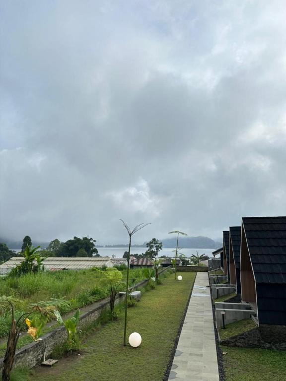 een loopbrug naar een huis met uitzicht op de oceaan bij Sai Wana Cabin Bedugul in Bedugul
