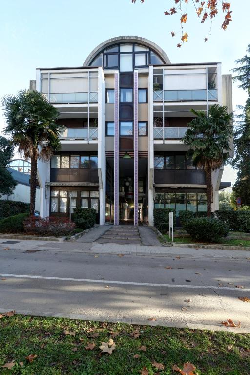 an office building with palm trees in front of it at Residence Concordia in Gorizia