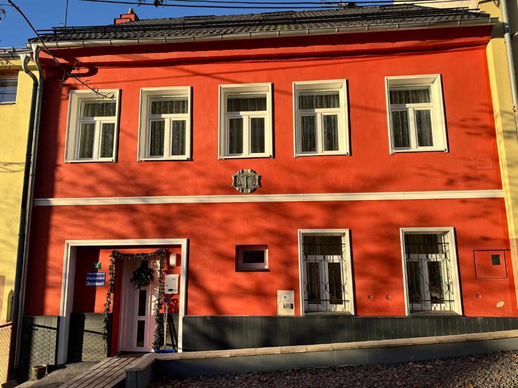 een rood gebouw met witte ramen en een deur bij U Váhy Jáchymov in Jáchymov