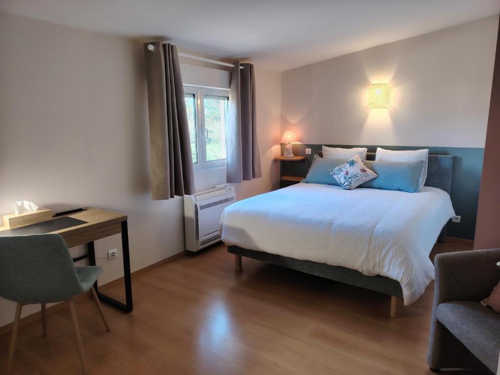 een slaapkamer met een bed, een bureau en een stoel bij Maison d'hôtes Beauregard in Donneville