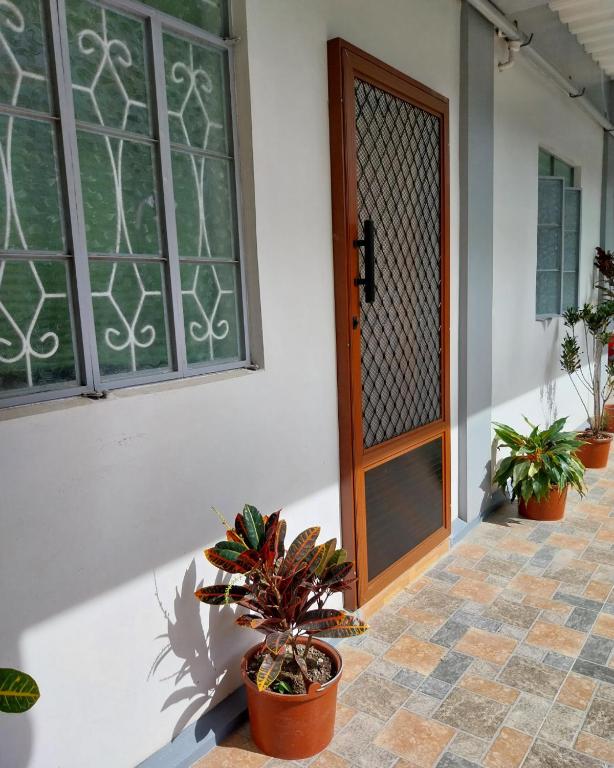 een voordeur van een huis met potplanten bij Ag-agongan Lodge in Baguio