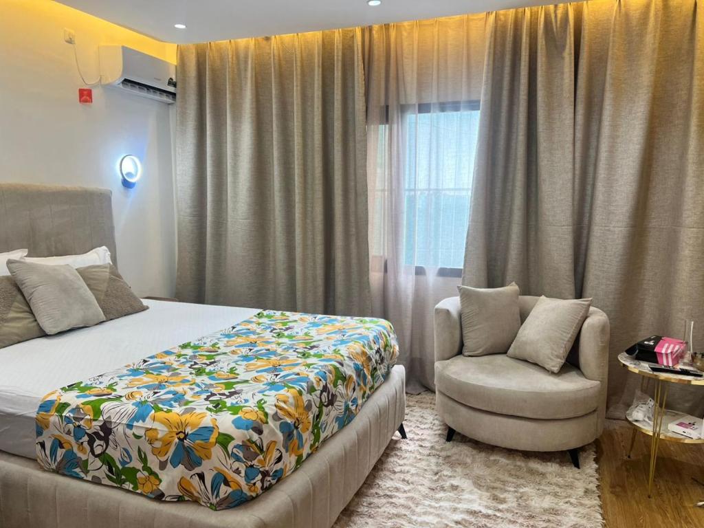 ein Schlafzimmer mit einem Bett, einem Stuhl und einem Fenster in der Unterkunft 113 k-chimi in Pointe-Noire