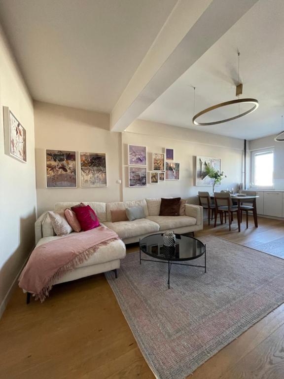 a living room with a couch and a table at The Gallery Apartment in Prishtinë