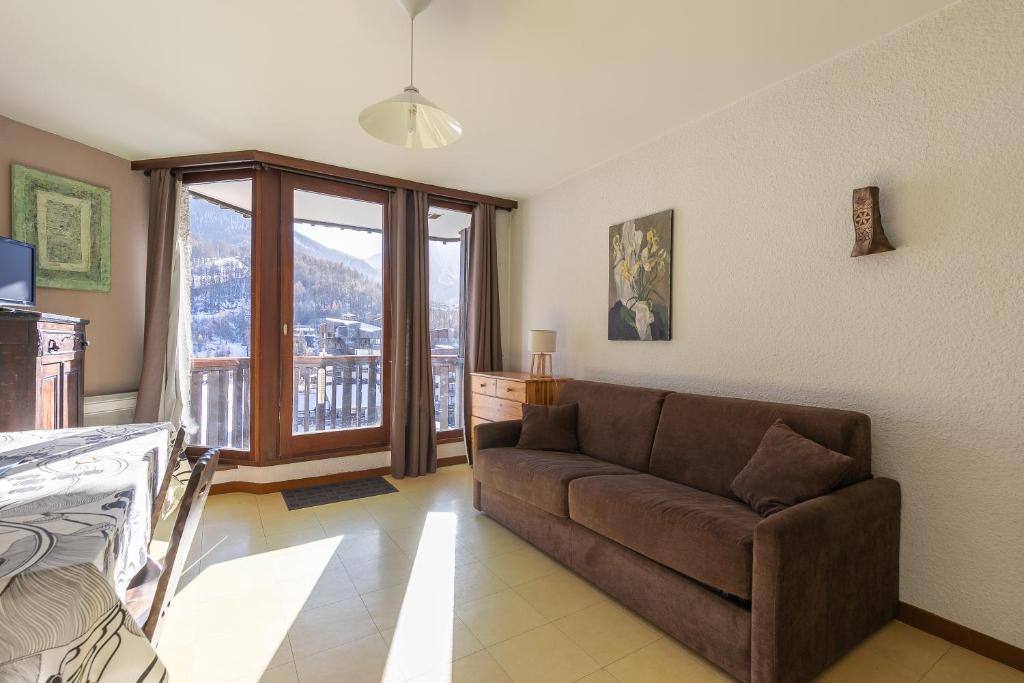 a living room with a couch and a balcony at Les Orres Plein Sud - Studio avec balcon in Les Orres