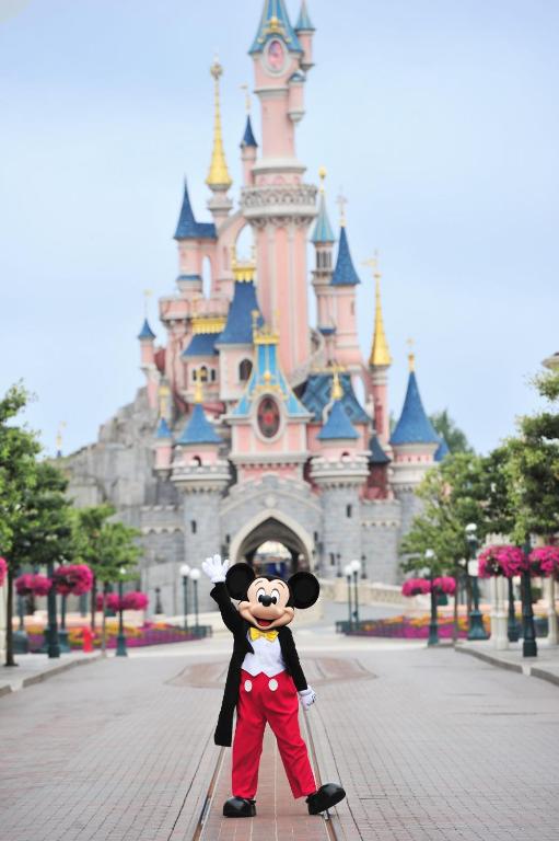 a mickey standing in front of a castle at Disney 4 min, from 4 to 14 Guests, 4 bedrooms, free parkings, 100 m2 in Chessy