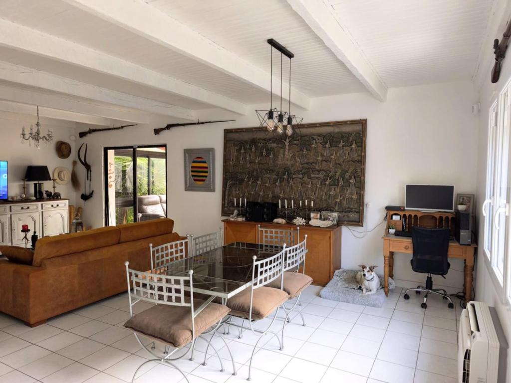 a living room with a glass table and chairs at La 1848 Narbonnaise in Narbonne