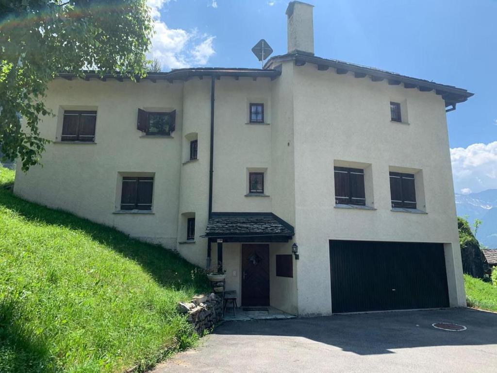 a large white house with a garage at Pedecosta in Poschiavo