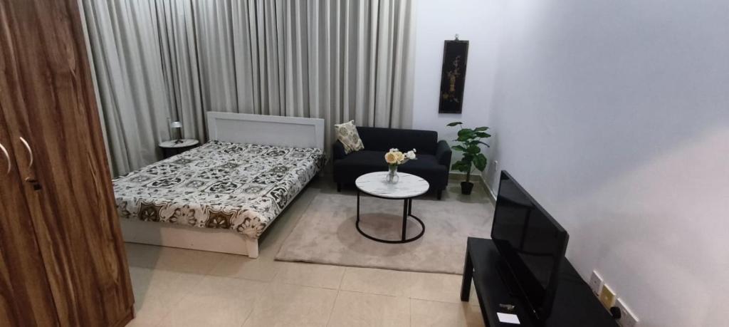 een kleine woonkamer met een bed en een tafel bij Ramco Real Estate LLC in Abu Dhabi