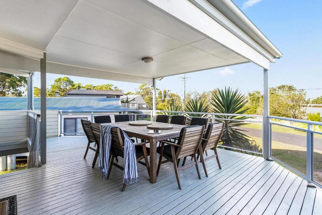un patio avec une table et des chaises sur une terrasse dans l'établissement Dream Weaver, à Bawley Point