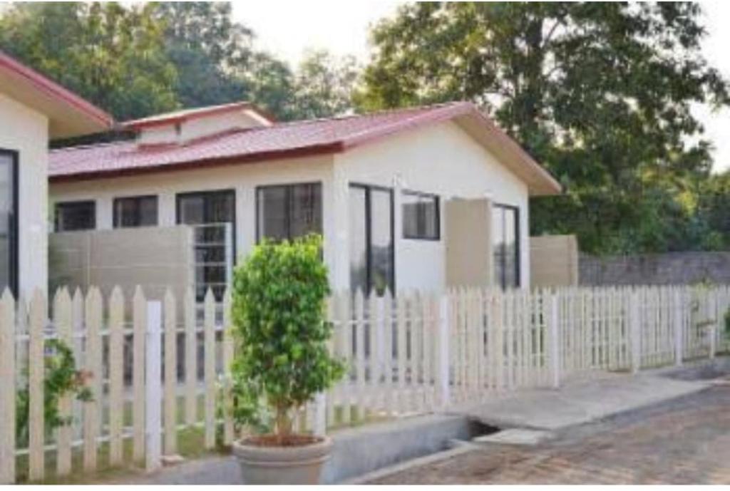 a white fence in front of a house at Aarex 63B Sparsh Chalet in Dhamni
