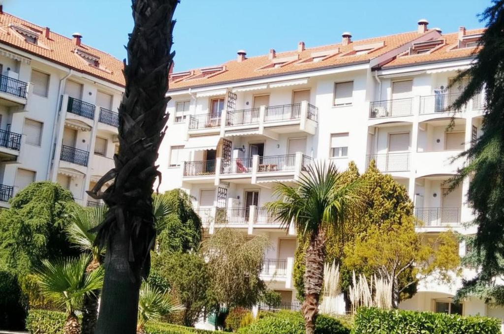 a building with palm trees in front of it at Condominio Ariazzurra S. Bart. in San Bartolomeo al Mare