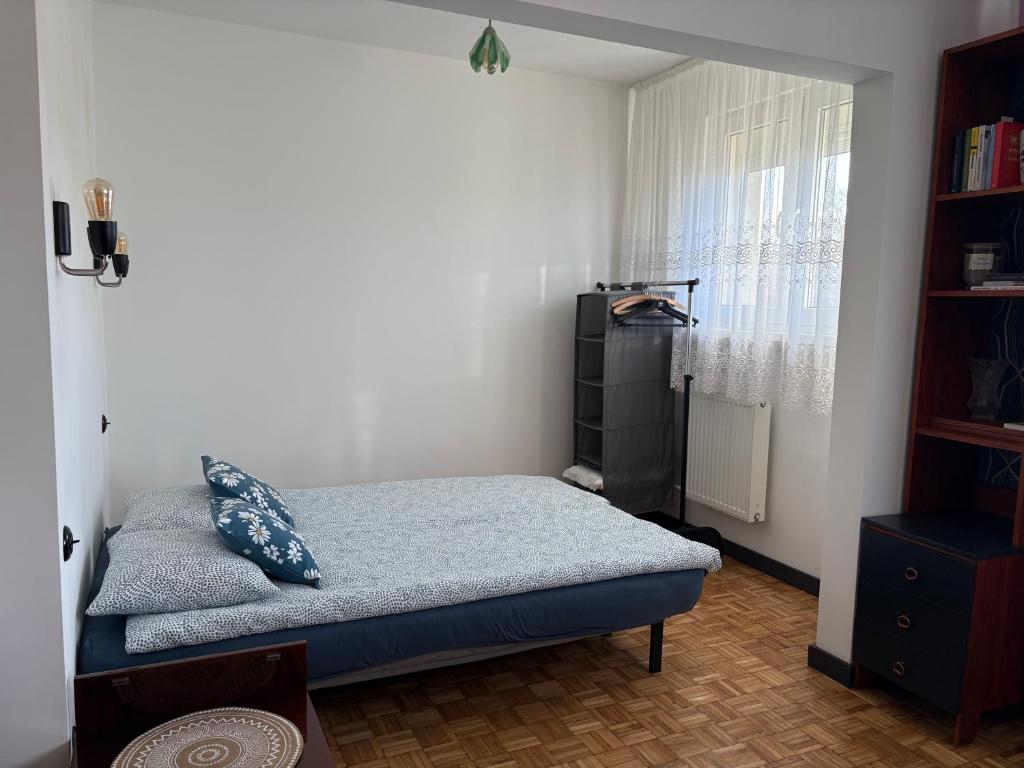 een kleine slaapkamer met een bed en een raam bij U Reni in Bydgoszcz
