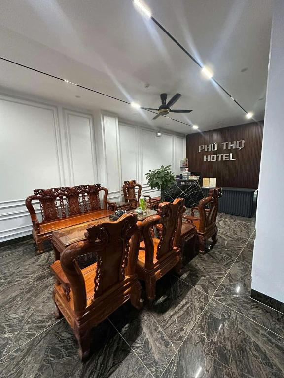 a room with a table and chairs and a ceiling fan at Phú Thọ Hotel in Chú Mật