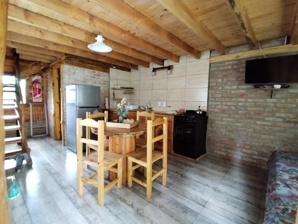 une cuisine avec une table en bois et un réfrigérateur dans l'établissement El Estribo, à Lago Puelo