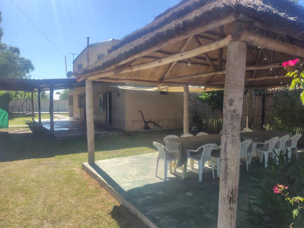 een patio met een tafel en stoelen onder een paviljoen bij Complejo Cabañas del Cristo in San Rafael