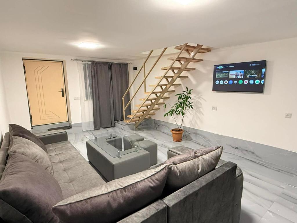 un salon avec un canapé et un escalier dans l'établissement Garden EVN Apartments, à Erevan