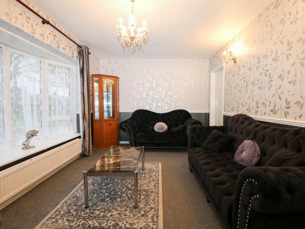 a living room with a couch and a table at Green Bank in Dymchurch