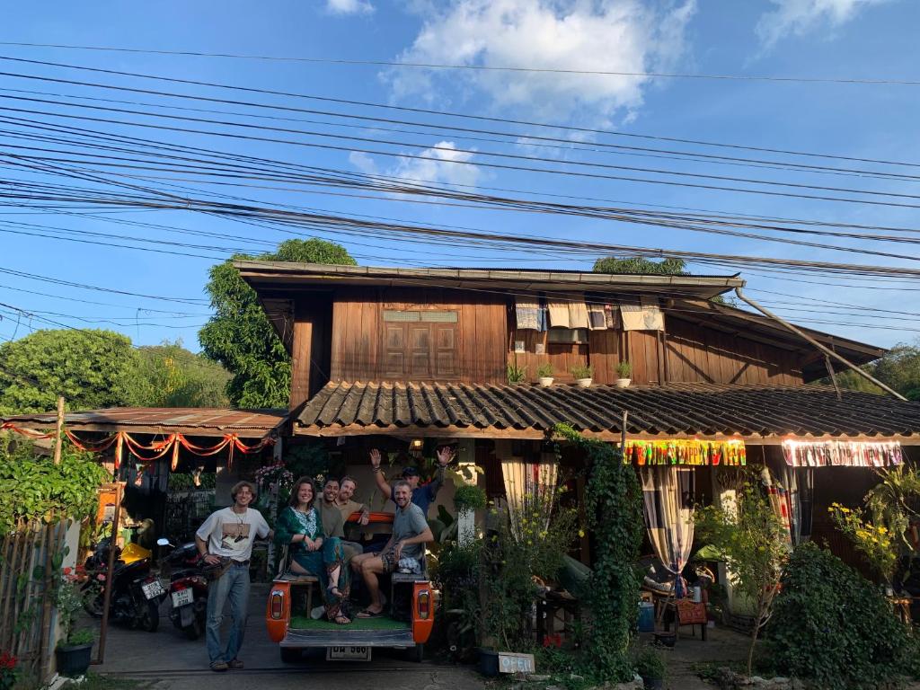 een groep mensen die voor een huis staan bij Ka Prao Kai Hostel in Pai