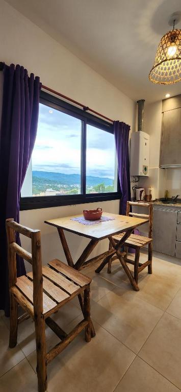 a table and benches in a kitchen with a large window at EmBruHadas Violet in San Salvador de Jujuy