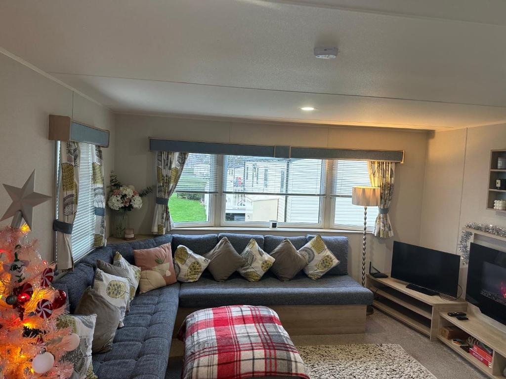 a living room with a blue couch and a television at Horizon Bay in Longniddry