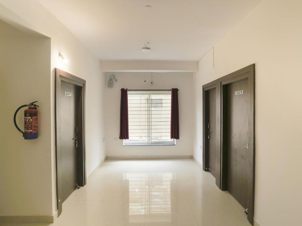 an empty hallway with two doors and a window at Super Hotel O Prashant Villa in Rānchī