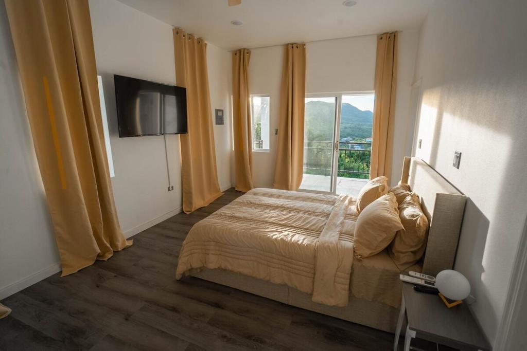 een slaapkamer met een bed en een groot raam bij Luxury Apt with Amazing Views in Saint Johnʼs