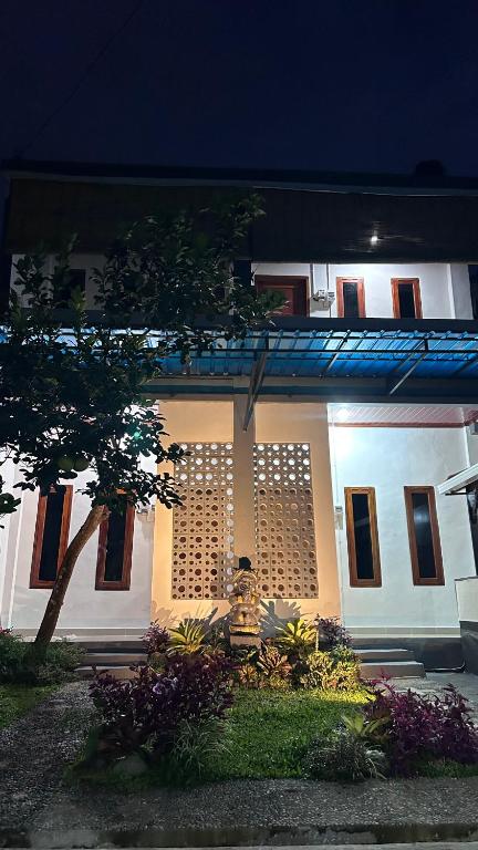 a white building with a lot of windows at night at Mars Homestay Ubud in Ubud