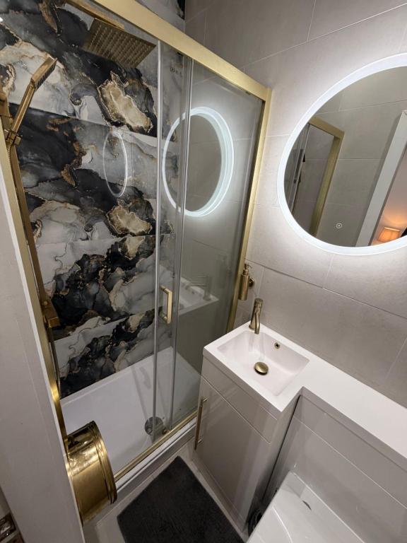 ein Badezimmer mit Toilette, Waschbecken und Spiegel in der Unterkunft Hendham Rooms in Manchester