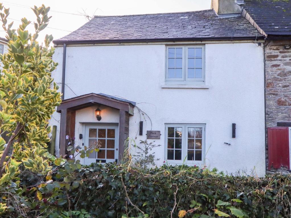 a white house with a fence in front of it at Park Cottage in Kingsbridge