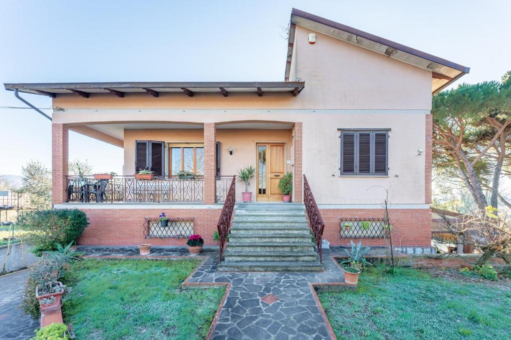 a house with a staircase leading to the front door at Casa nella campagna Toscana in Vinci
