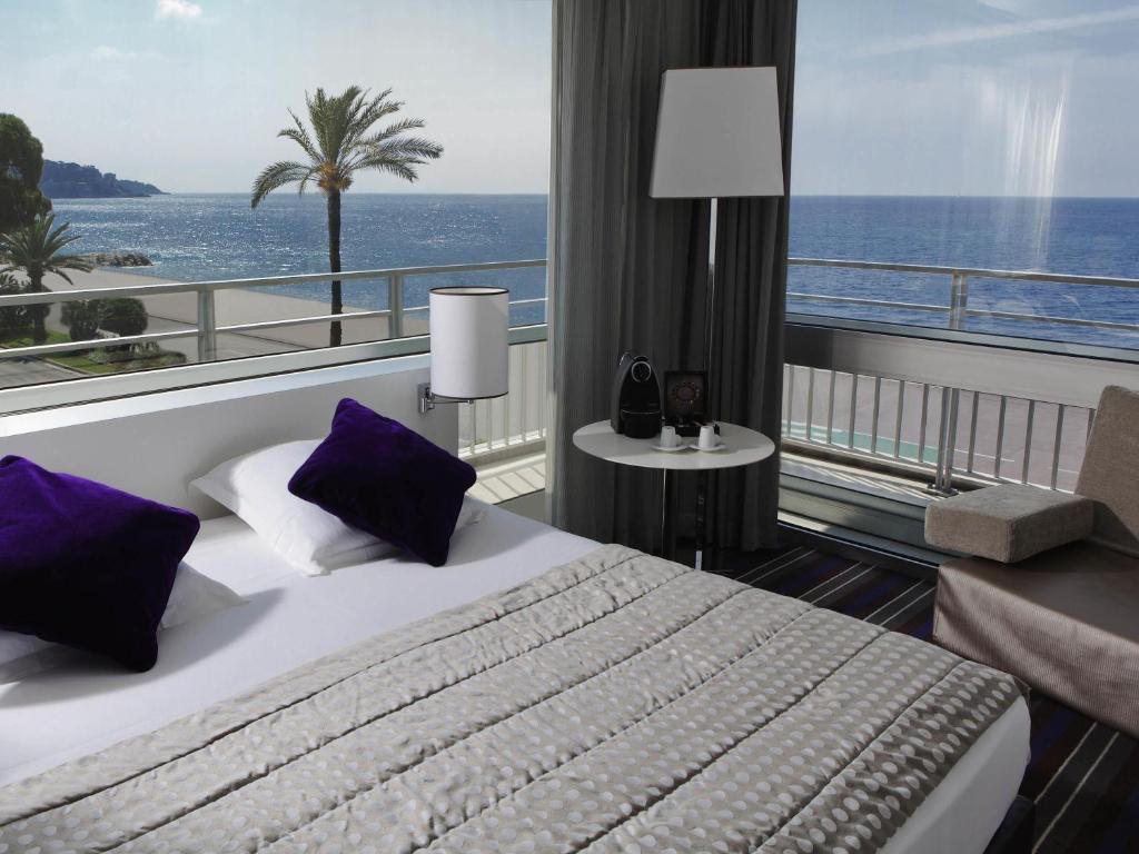 une chambre d'hôtel avec un lit et une vue sur l'océan dans l'établissement Mercure Nice Promenade Des Anglais, à Nice