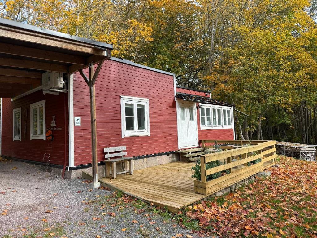 una casa rossa con un ponte di legno accanto ad essa di Spokhuset a Kättilstorp