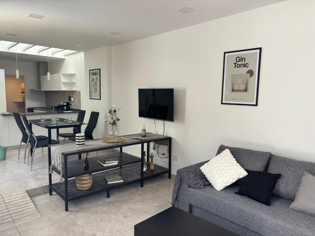 een woonkamer met een bank en een eetkamer bij Patios de City Bell Hotel and Apartments in City Bell