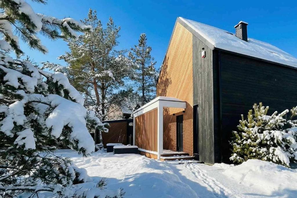 ein Gebäude im Schnee mit schneebedeckten Bäumen in der Unterkunft Willa Horyzont Borsk in Borsk