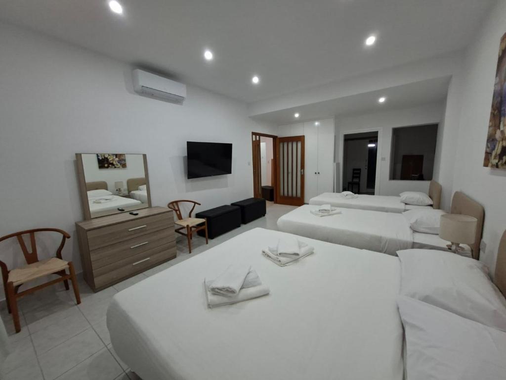 ein Hotelzimmer mit zwei Betten und einem Spiegel in der Unterkunft Twin Beds Standard Studios by Kentrikon 1924 Hotel, Old Town in Paphos City