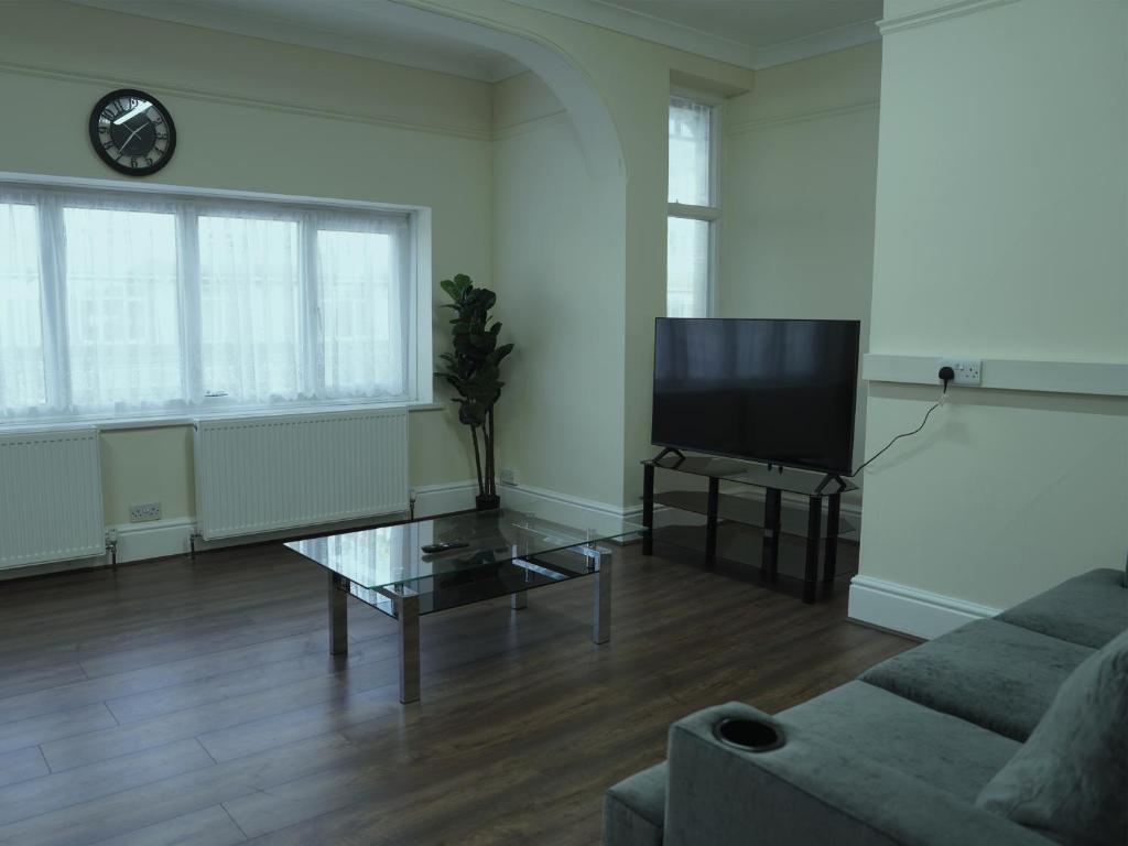 a living room with a couch and a tv at SS Sunrise & Silk in Bognor Regis
