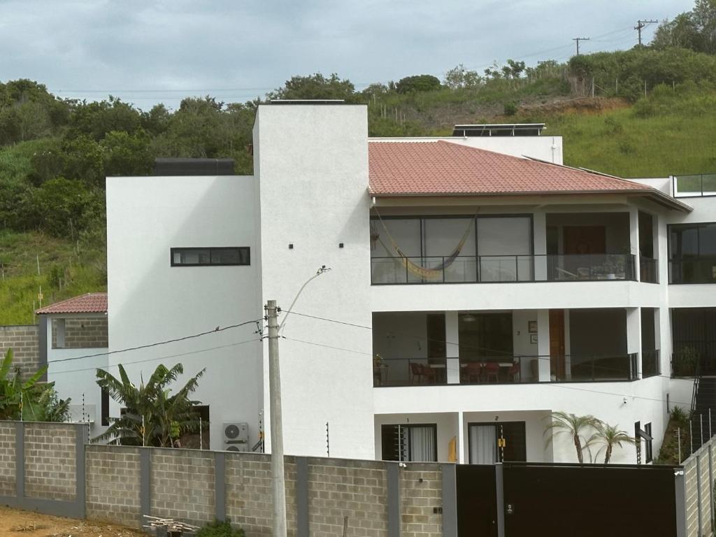 a white house with a fence in front of it at Casa MarSol in Piúma