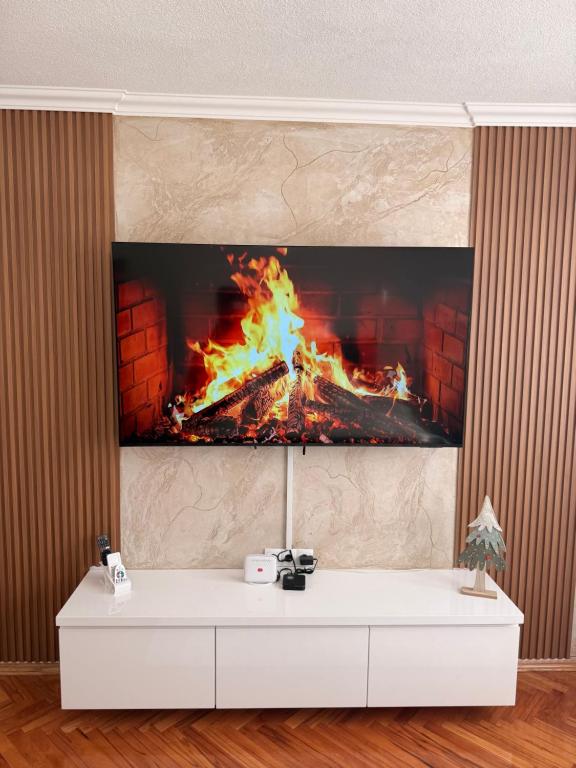 a tv on a wall with a fire in a fireplace at Apartman Andrea in Brčko