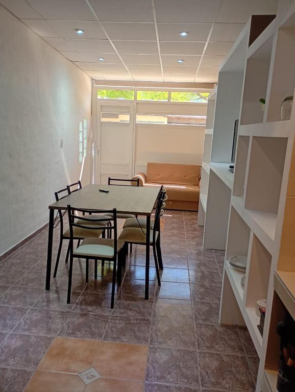a dining room with a table and chairs and a couch at Alojamiento Gral Alvear in General Alvear