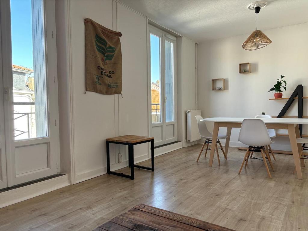 een woonkamer met een tafel en een tafel en stoelen bij Soleil urbain in Périgueux