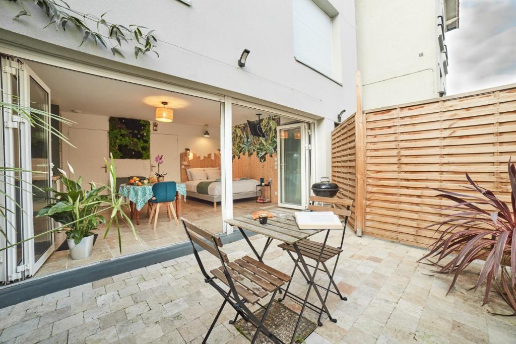 un patio avec une table et des chaises et un salon dans l'établissement Studio LILAS avec terrasse au calme, à Montreuil