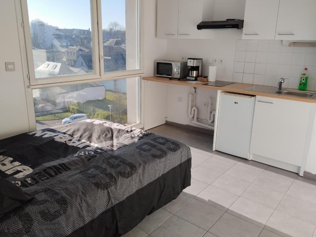 een keuken met een bed en een groot raam bij Studio centre Rouen rive gauche au pied du T4 in Le Petit-Quevilly
