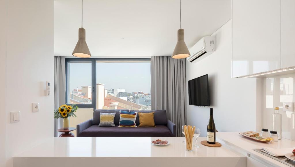 uma sala de estar com um sofá e uma grande janela em Lisbon Serviced Apartments - Parque em Lisboa