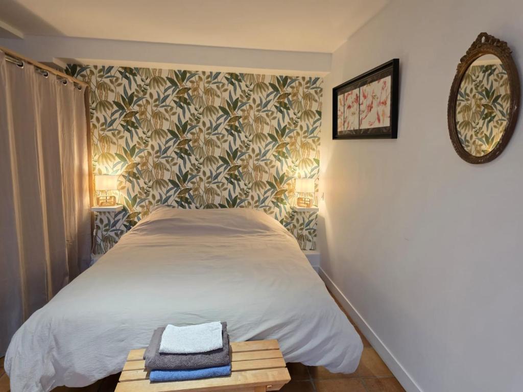 ein Schlafzimmer mit einem Bett und einem Spiegel in der Unterkunft Studio 2 personnes proche du Futuroscope in Beaumont