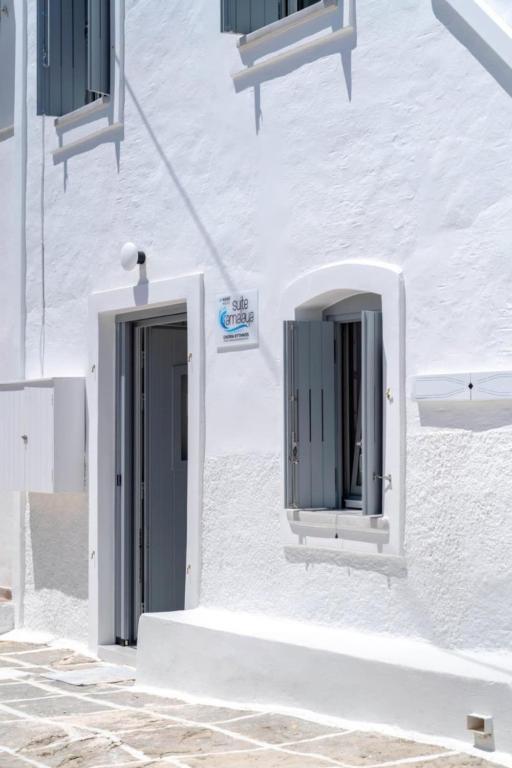 a white building with a door and a window at Suite Amalaya Κατώι in Kithnos